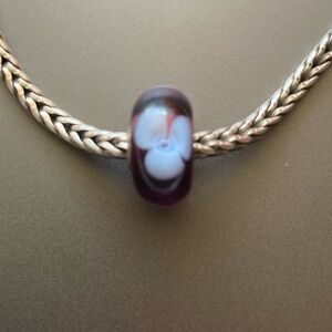 Trollbead dark and light purple glass bead with flower design